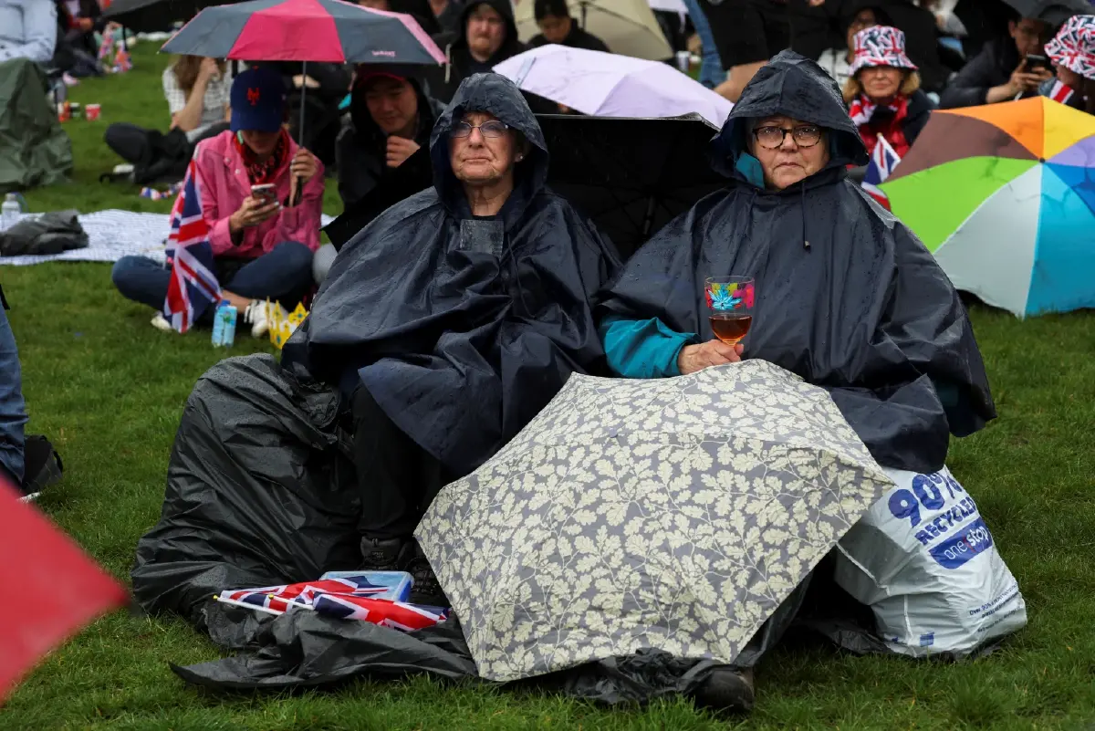 แฟนคลับราชวงศ์ปักหลักชมพระราชพิธีท่ามกลางฝนตก