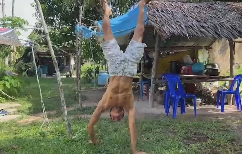 สุดทึ่ง! หนุ่มโชว์พลังคอแข็ง ห้อยกับคานไม้ แถมถือถังทรายหนัก 20 กก.