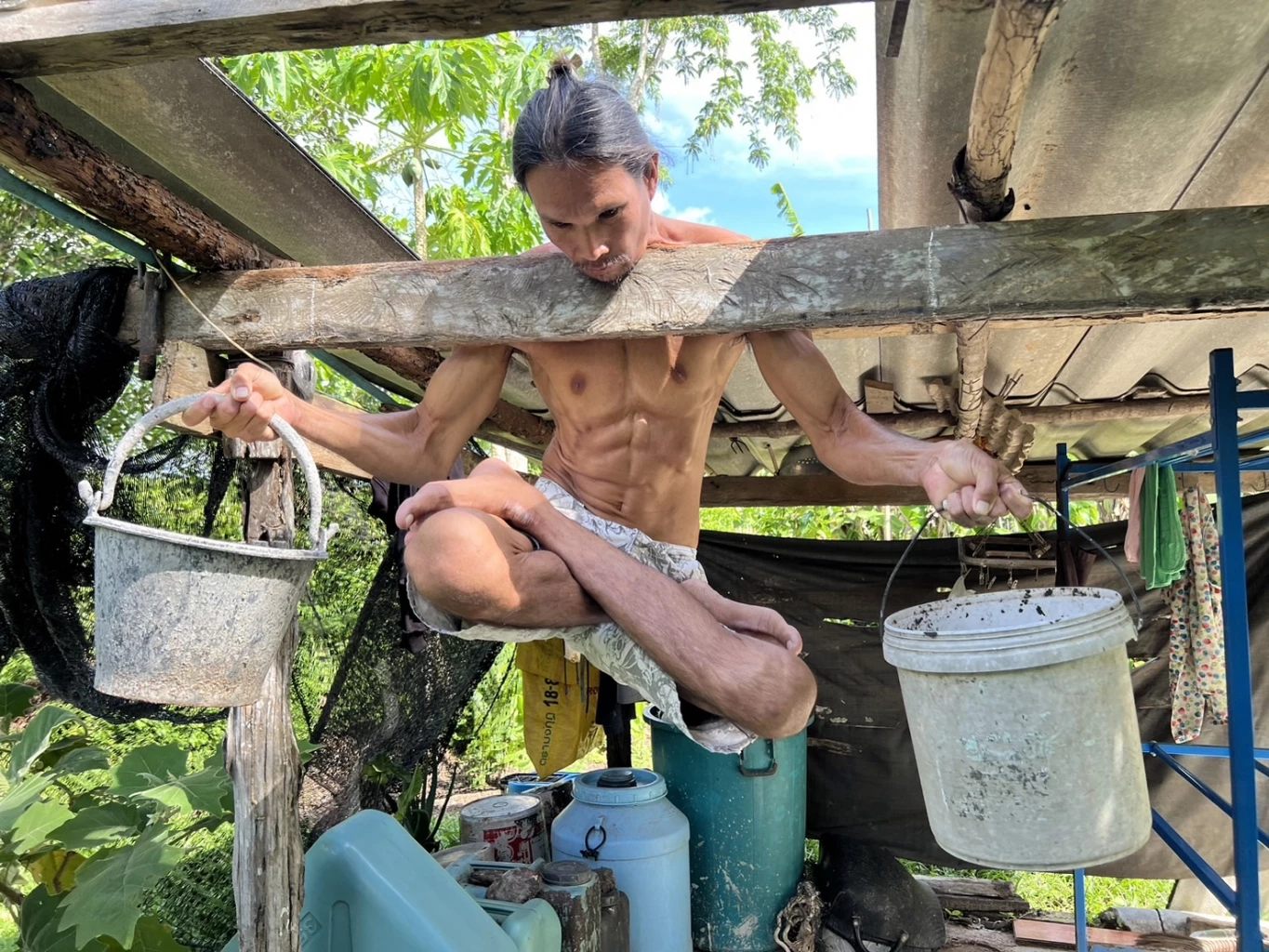 สุดทึ่ง! หนุ่มโชว์พลังคอแข็ง ห้อยกับคานไม้ แถมถือถังทรายหนัก 20 กก.