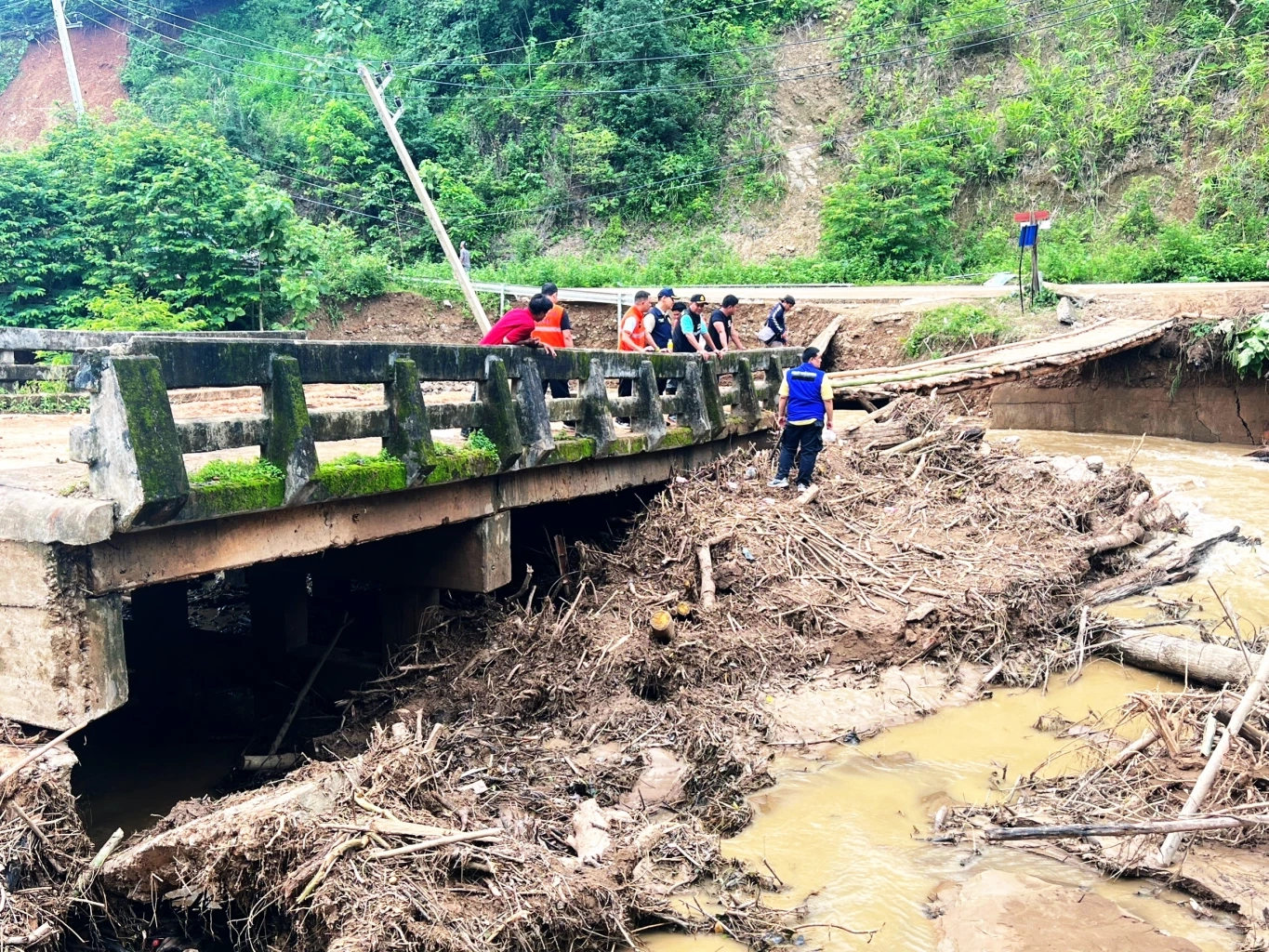 ชาวบ้านร่วมใจ ช่วยกันสร้างสะพานไม้ชั่วคราวข้ามลำห้วย หลังถูกน้ำป่าตัดขาด