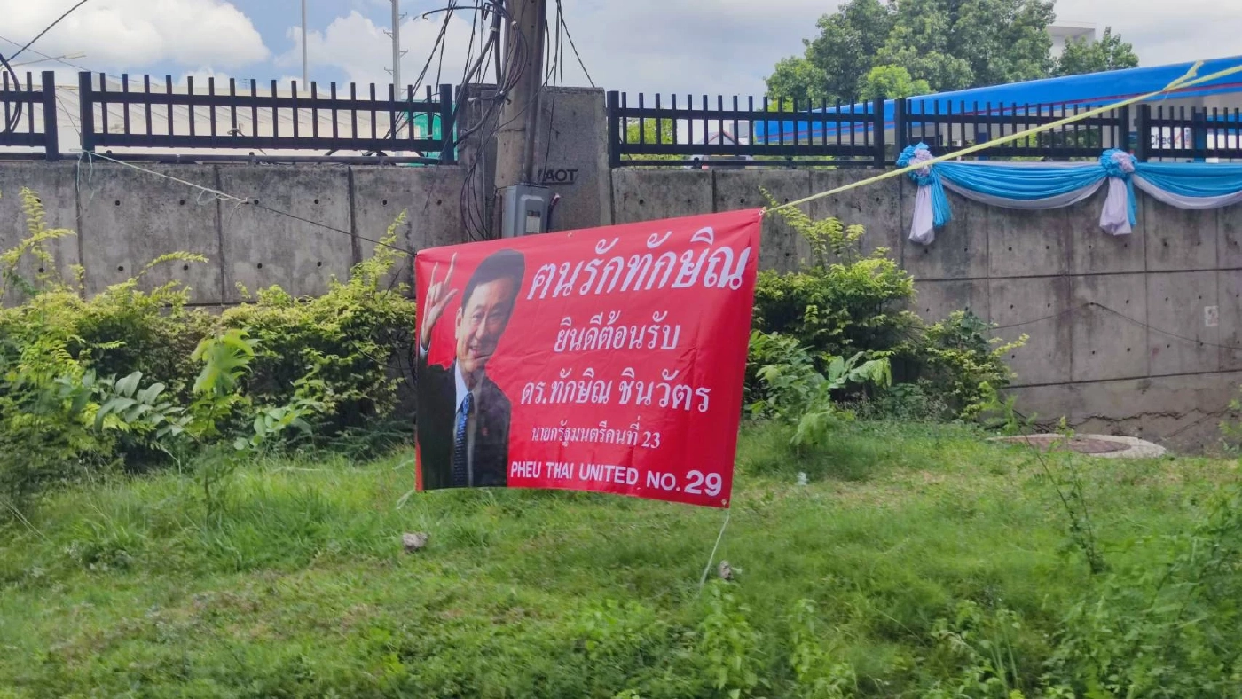 คนเสื้อแดง แห่ติดป้ายต้อนรับ “ทักษิณ” กลับไทยรอบสนามบินดอนเมือง