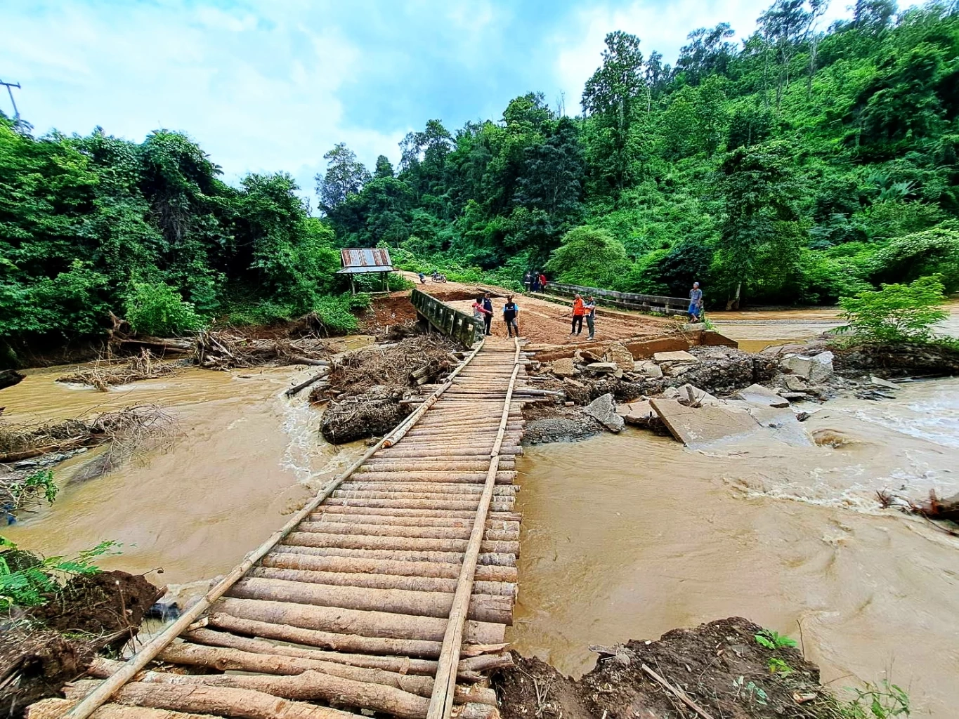 ชาวบ้านร่วมใจ ช่วยกันสร้างสะพานไม้ชั่วคราวข้ามลำห้วย หลังถูกน้ำป่าตัดขาด