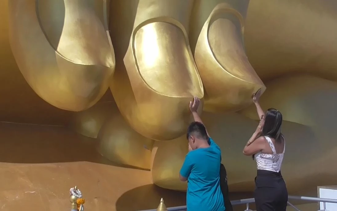 พุทธศาสนิกชนพาครอบครัวไหว้พระ แตะปลายนิ้วขอพร "หลวงพ่อใหญ่" วัดม่วง