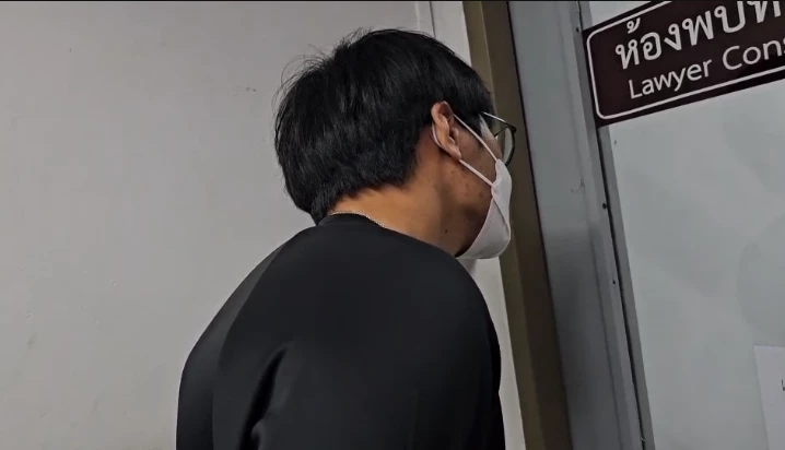 พี่ชายนายแซนยืนดูน้องในห้องควบคุมตัว