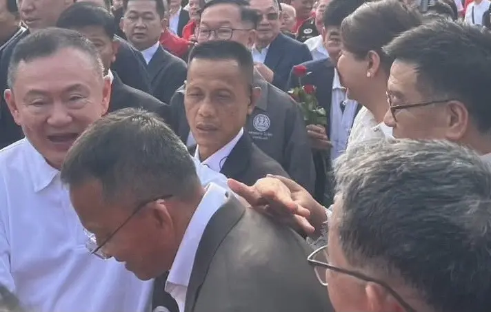 ทักษิณ ทักทายสมศักดิ์ โดยมียงยุทธ ยืนอยู่ใกล้ๆ ที่หน้าเรือนจำ