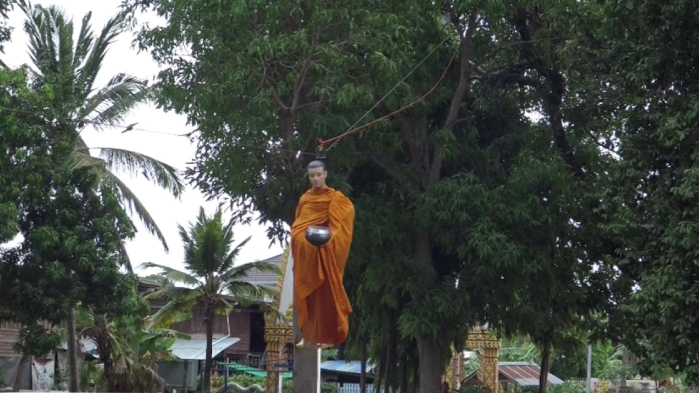 ฮือฮา หุ่นพระสงฆ์ลอยลงมาจากต้นไม้รับบิณฑบาตจีวรปลิว
