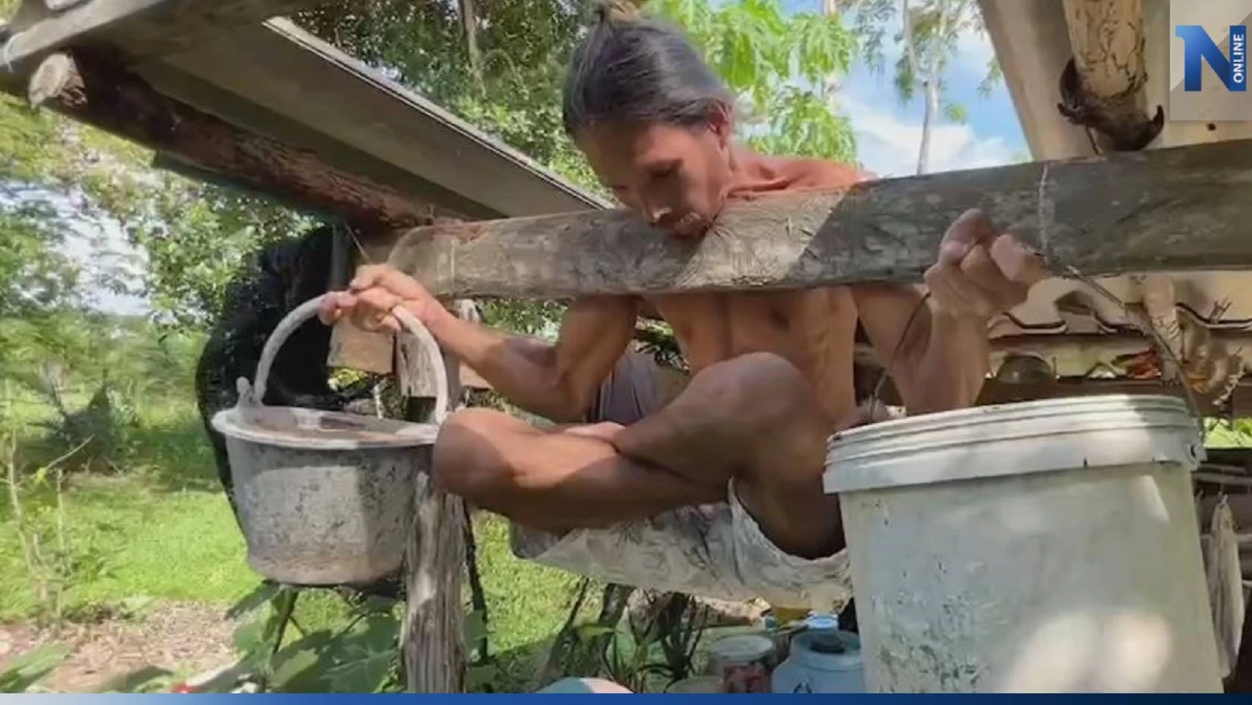 สุดทึ่ง! หนุ่มโชว์พลังคอแข็ง ห้อยกับคานไม้ แถมถือถังทรายหนัก 20 กก.